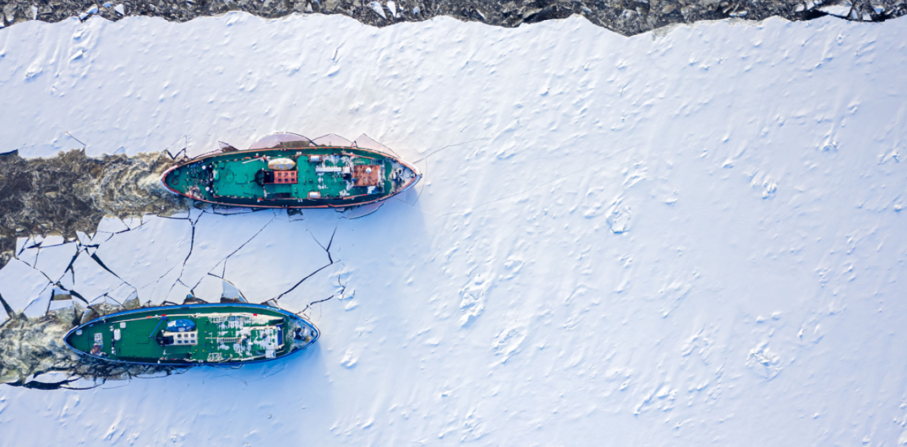 Ice breakers crush through the ice in an aerial shot