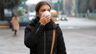 COVID-19 Pandemic Coronavirus Woman in city street wearing protective face mask 