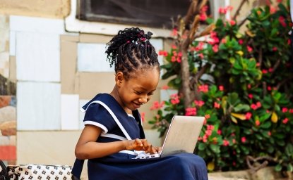 Young African girl working on a laptop computer. 