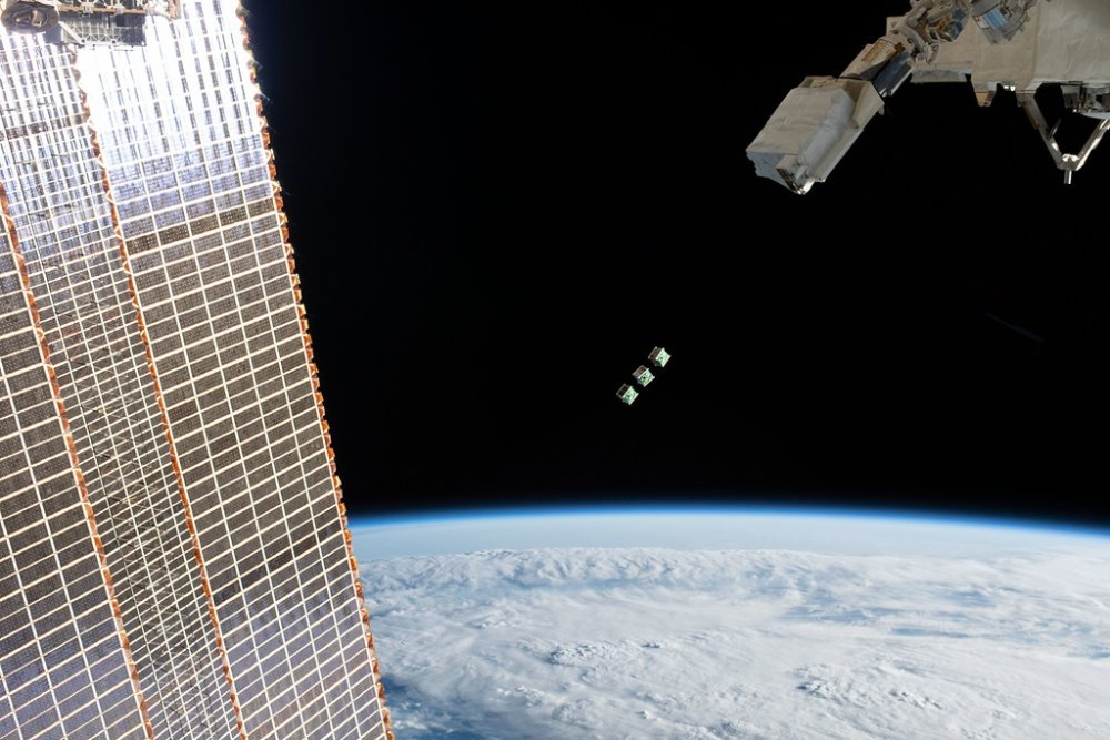 Three CubeSats being released into space