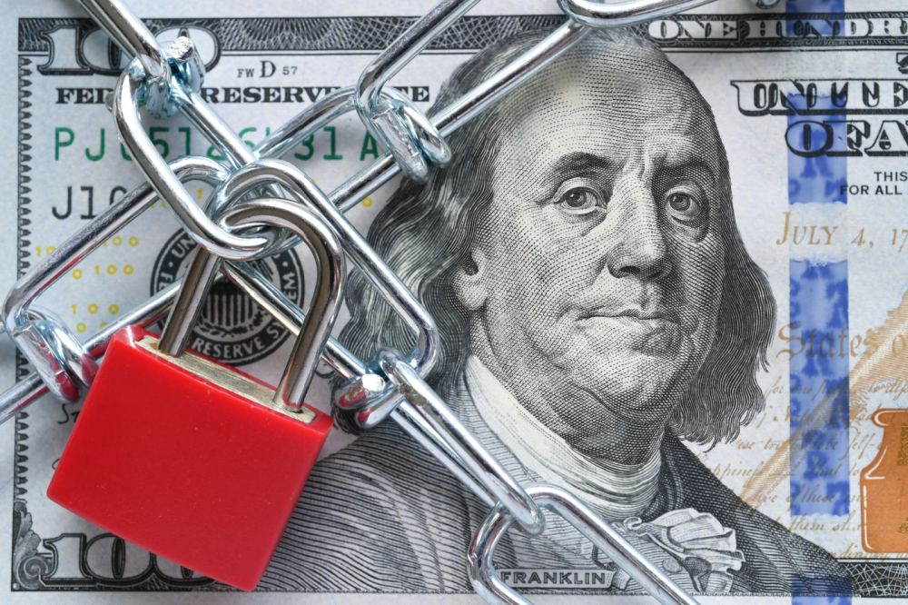 Photo of a lock and chain across a $100 bill