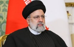 A picture of President Ebrahim Raisi seated in front of an Iranian flag.